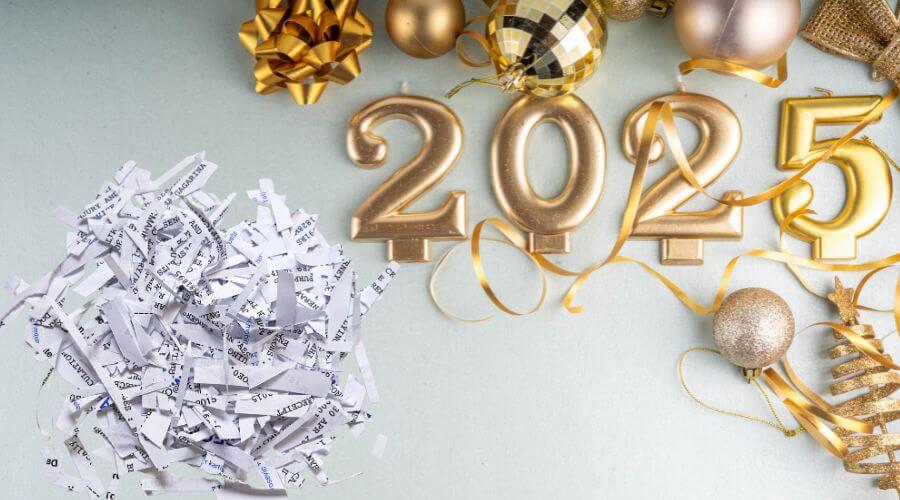 Image of gold balloons that say 2025 next to a pile of shredded paper